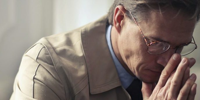 coping with suicide bereavement 1438×344 website man sitting on couch heads down coping with suicide bereavement