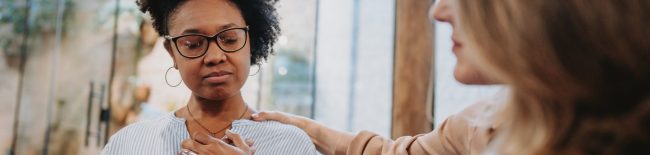woman with eyes closed and hands on chest with another hand on her shoulder. how you might feel after a suicide