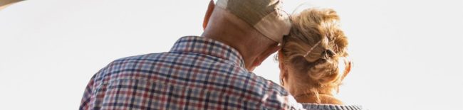 elderly couple with arm around one person showing support after suicide