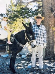 Amy on a donkey with her dad Dirk beside her