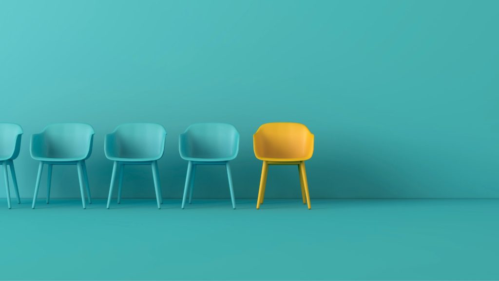 a row of green chairs and one yellow chair