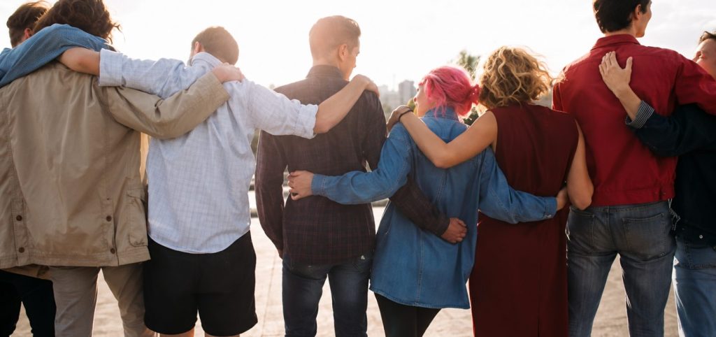 group of young people hugging each other and looking at the sky