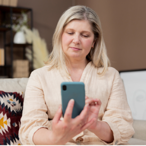 woman with blonde hair looking at her iphone